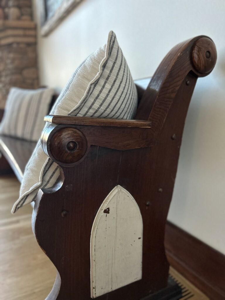 Wooden pew bathed in natural light, representing sacred stillness and soul-rooted rest at Ingrained Living.